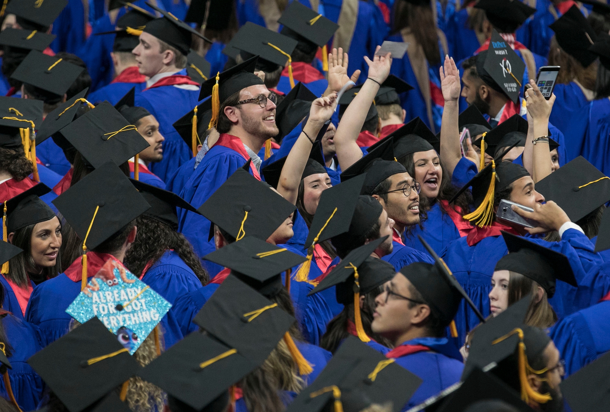 Driehaus College of Business graduates wave to friends and family members inside Wintrust Arena as they take to the floor for their commencement ceremony. (DePaul University/Jamie Moncrief)
